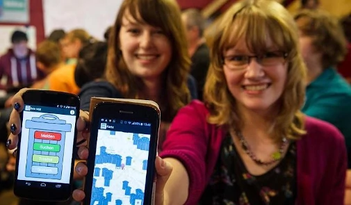Zwei Mädchen zeigen Smartphone-App Dein Müll