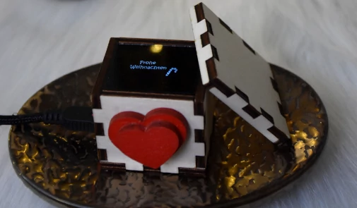 Foto der geöffneten Lovebox, also eine Holzschachtel mit bewegbaren Herz an der Vorderseite und einem Display innendrin